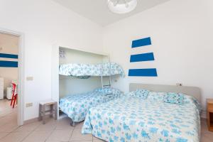 - une chambre avec 2 lits avec des draps bleus et blancs dans l'établissement Nicola House Il Faro, à Cervia