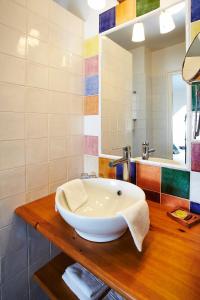 een badkamer met een grote witte wastafel op een houten aanrecht bij Carnac Lodge Hotel & Spa in Plouharnel
