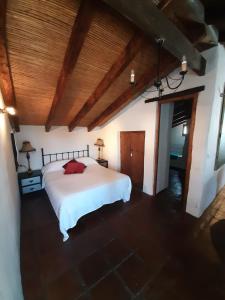 a bedroom with a white bed and a wooden ceiling at Attico Los Montes with private pool in Viñuela