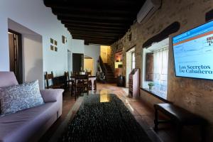 a living room with a couch and a tv at Casa Rural Tornerías in Cuerva