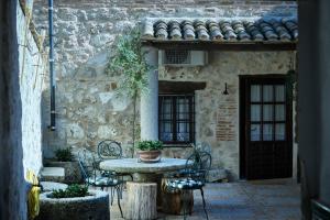 an outdoor table and chairs in a stone building at Casa Rural Tornerías in Cuerva