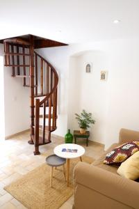 a living room with a couch and a spiral staircase at Proa d'Alfama Guest House in Lisbon