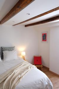 a bedroom with a white bed and a red chair at Proa d'Alfama Guest House in Lisbon