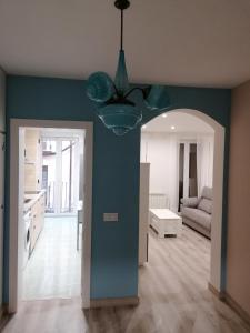 a living room with a blue wall and a ceiling fan at Apartamentos El Cid in Molina de Aragón