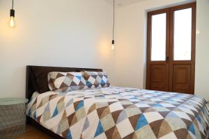 a bedroom with a bed with a colorful comforter at Casa do Pilar - D Maria Pia in Vila Nova de Gaia