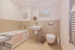 a bathroom with a sink and a toilet and a bath tub at Modern and chic city centre apartment with parking in Oxford