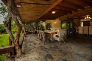 an outdoor patio with a wooden table and chairs at Adventure Bush Villa in Marloth Park