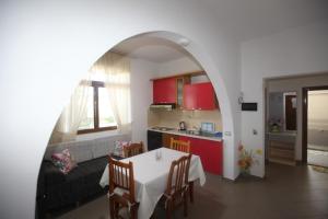 a kitchen and a living room with a table and chairs at Villa Oden in Ksamil