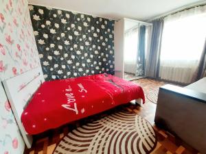 a bedroom with a red bed with a floral wall at Yanovskogo 3k in Kropyvnytskyi