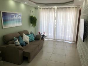 a living room with a couch and a large window at Le Bon Vivant Arraial beach in Arraial do Cabo