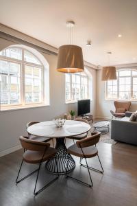 a living room with a table and chairs at Mirabilis Apartments - Bayham Place in London