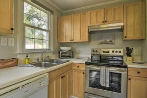 a kitchen with wooden cabinets and a stove top oven at Raleigh ITB Home - Mins to Downtown and North Hills! in Raleigh