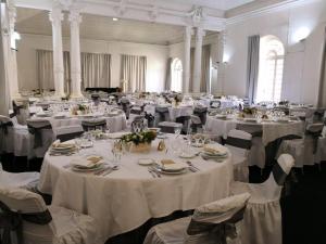 a large banquet hall with white tables and chairs at Hotel Termas da Curia in Curia