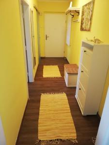 un pasillo con paredes amarillas, suelo de madera y alfombras en Apartment Graz Lustbuhel en Graz