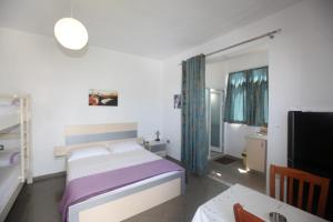 a bedroom with a bed and a table and a tv at Villa Oden in Ksamil