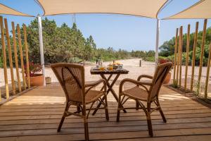 un tavolo e sedie su una terrazza in legno con ombrellone di Cas Saliners - La Savina a La Savina