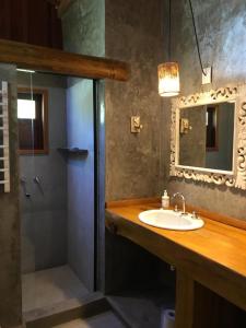 a bathroom with a sink and a mirror and a shower at Chalés Mathora in Visconde De Maua