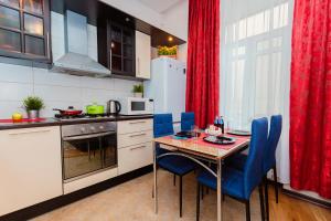 a kitchen with a table and blue chairs in a kitchen at Lakshmi Lux Apartment Arbat Modern in Moscow