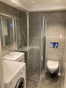een badkamer met een douche, een toilet en een wastafel bij Skansen Apartments in Bergen +43 foto's