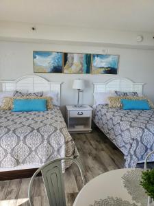 a bedroom with two beds and a table and chairs at 426 Belle Vue Magnificent Oceanfront studio with two balconies in Myrtle Beach