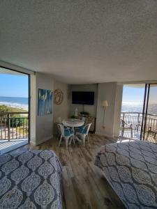 a bedroom with a bed and a table with chairs at 426 Belle Vue Magnificent Oceanfront studio with two balconies in Myrtle Beach