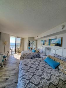 a bedroom with two beds and a view of the ocean at 426 Belle Vue Magnificent Oceanfront studio with two balconies in Myrtle Beach