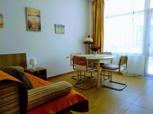 ソゾポルにあるApartments Elinor Budjakaのテーブル、椅子、ベッドが備わる客室です。