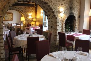 a restaurant with tables and chairs in a room with stone walls at Logis Hôtel - Le Manoir de Sauvegrain in Saint-Lambert