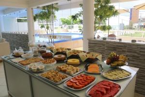 un buffet avec de nombreux types de nourriture sur une table dans l'établissement Hotel Belo Horizonte, à Natal