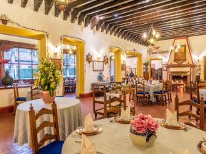 a restaurant with tables and chairs with flowers on them at Best Western Plus Posada de Don Vasco in Pátzcuaro