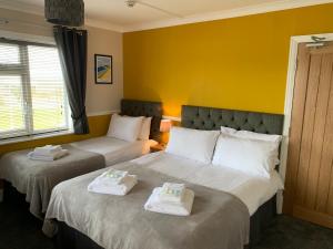 two beds in a hotel room with towels on them at The Headlands Hotel in Scarborough