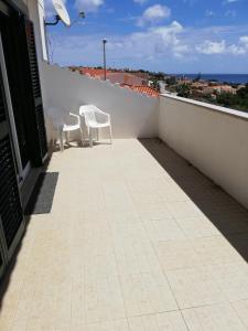 two chairs on a balcony with a view of the ocean at Moradia São Pedro in Porto Santo