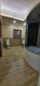 Una habitación grande con baño y pantalla de proyección. en Tranquillity Holiday Home, en Marloth Park