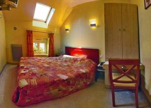 1 dormitorio con 1 cama grande y 1 mesa en Relais Du Lac, en Villegusien Le Lac