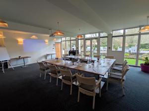 uma grande sala de conferências com uma grande mesa e cadeiras em Logis Hôtel & Restaurant - Le Manoir de Sauvegrain em Saint-Lambert