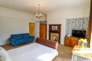 ein Wohnzimmer mit einem blauen Sofa und einem TV in der Unterkunft Hillcrest Whitby in Whitby
