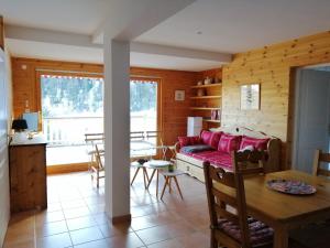 a living room with a red couch and a table at La Godille in Pra-Loup