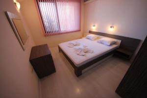 a small bedroom with a bed with towels on it at Menada Horyzont Apartments in Sozopol +47 photos