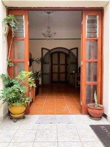 een open deur van een huis met potplanten bij La Chocita Ward in Lima