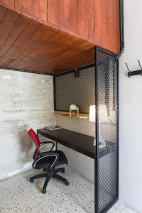 una oficina con escritorio y silla roja en Kim Haus Loft, en George Town