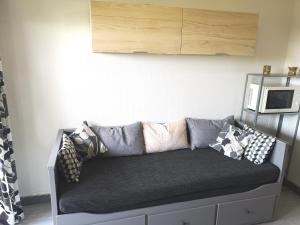 a couch with pillows on it in a living room at Ryo Beach in Courseulles-sur-Mer