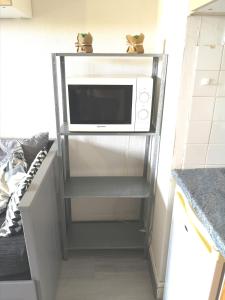 a microwave oven on a shelf in a kitchen at Ryo Beach in Courseulles-sur-Mer