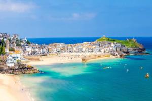 eine Luftaufnahme eines Strandes mit Menschen im Wasser in der Unterkunft Driftwood Cottage in Uny Lelant