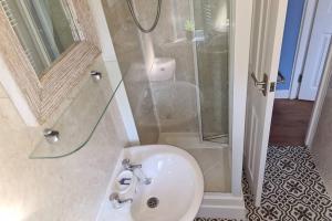 ein Badezimmer mit Waschbecken und Dusche in der Unterkunft Driftwood Cottage in Uny Lelant