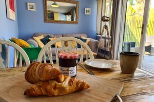 einen Tisch mit einem Croissant und einem Glas Marmelade in der Unterkunft Driftwood Cottage in Uny Lelant + 28 Fotos
