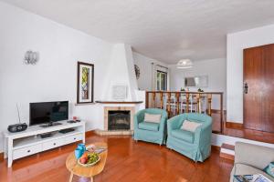 a living room with two chairs and a television at Villa Emilio Pequena by Villa Plus in Albufeira