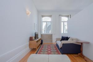 a living room with a couch and a tv at Liiiving In Porto | Bolhão Market Apartments in Porto
