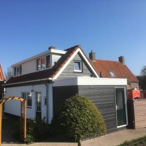 a small white house with a garage at Pinkeltje in Aagtekerke