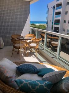 uma varanda com uma cama, cadeiras e uma mesa em Le Bon Vivant Arraial beach em Arraial do Cabo