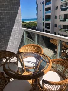 grupa wiklinowych krzeseł na balkonie z plażą w obiekcie Le Bon Vivant Arraial beach w mieście Arraial do Cabo